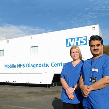 man and woman in front of mobile hearing clinic