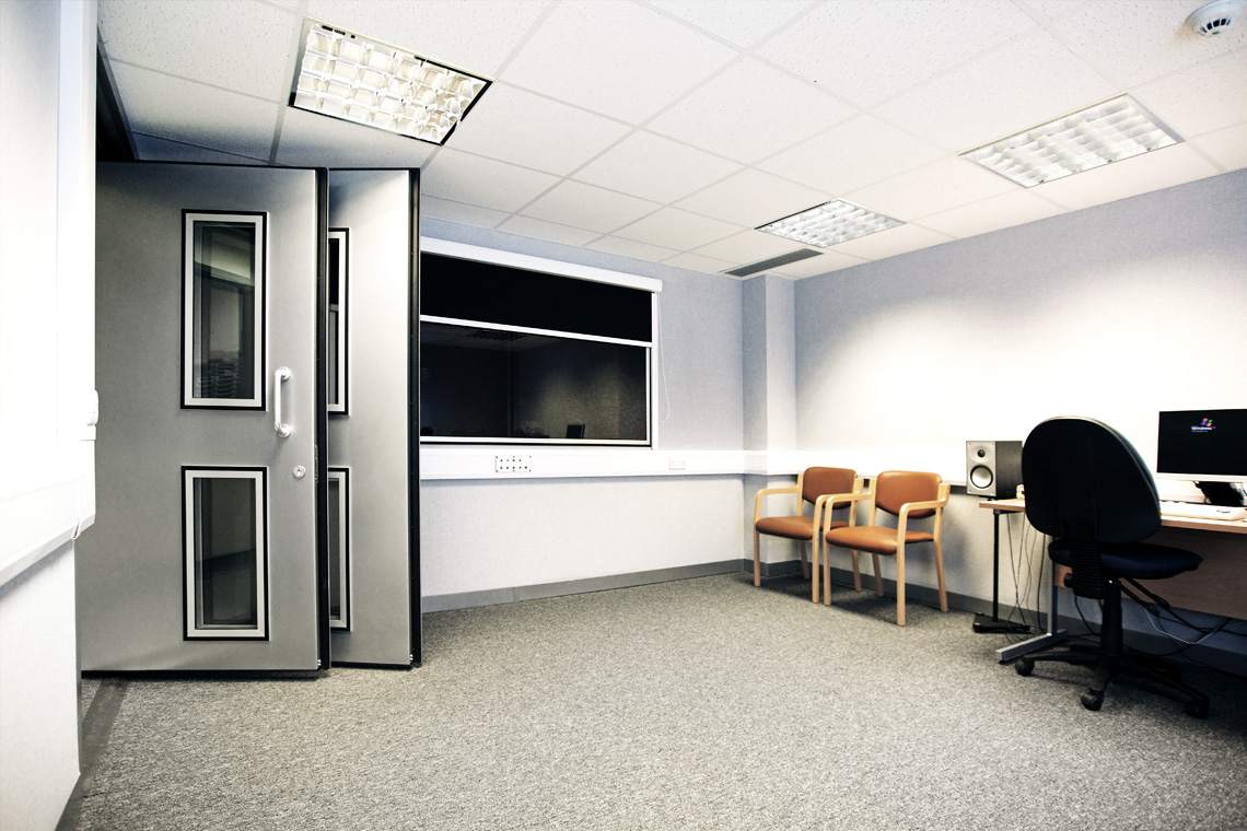large audiometric sound room with two doors and window to the control room