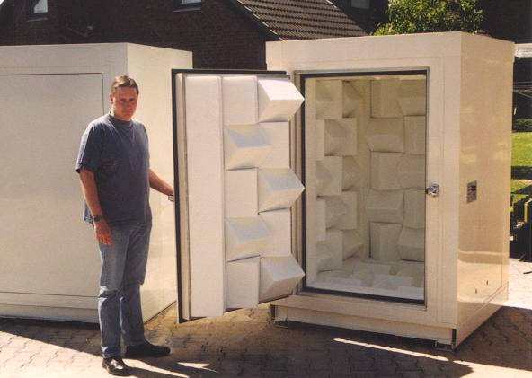 man opens the door to mini anechoic chamber in white colour